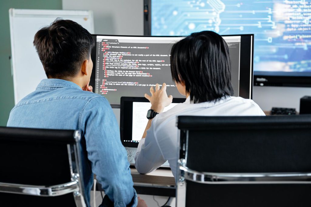 An image showing two people in front of a computer.