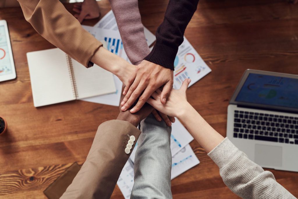 An image showing several people with crossed hands.