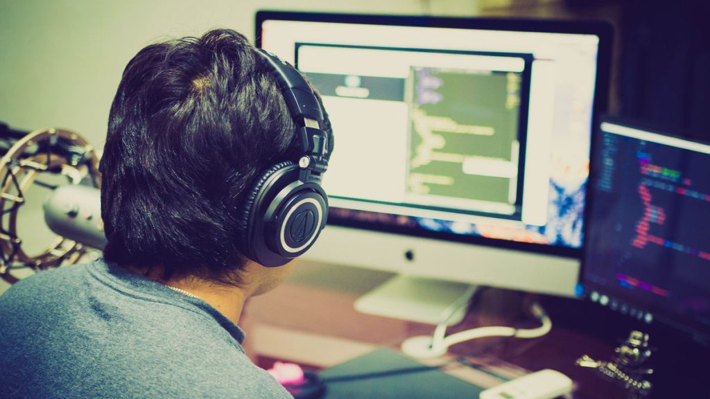 An image showing a man in front of two monitors.