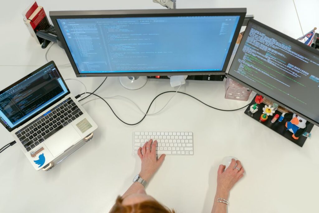 An image showing a person in front of some computer screens.