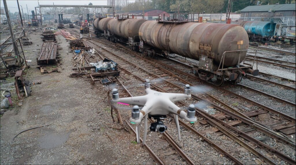 A screen showing a drone monitoring rail tracks.